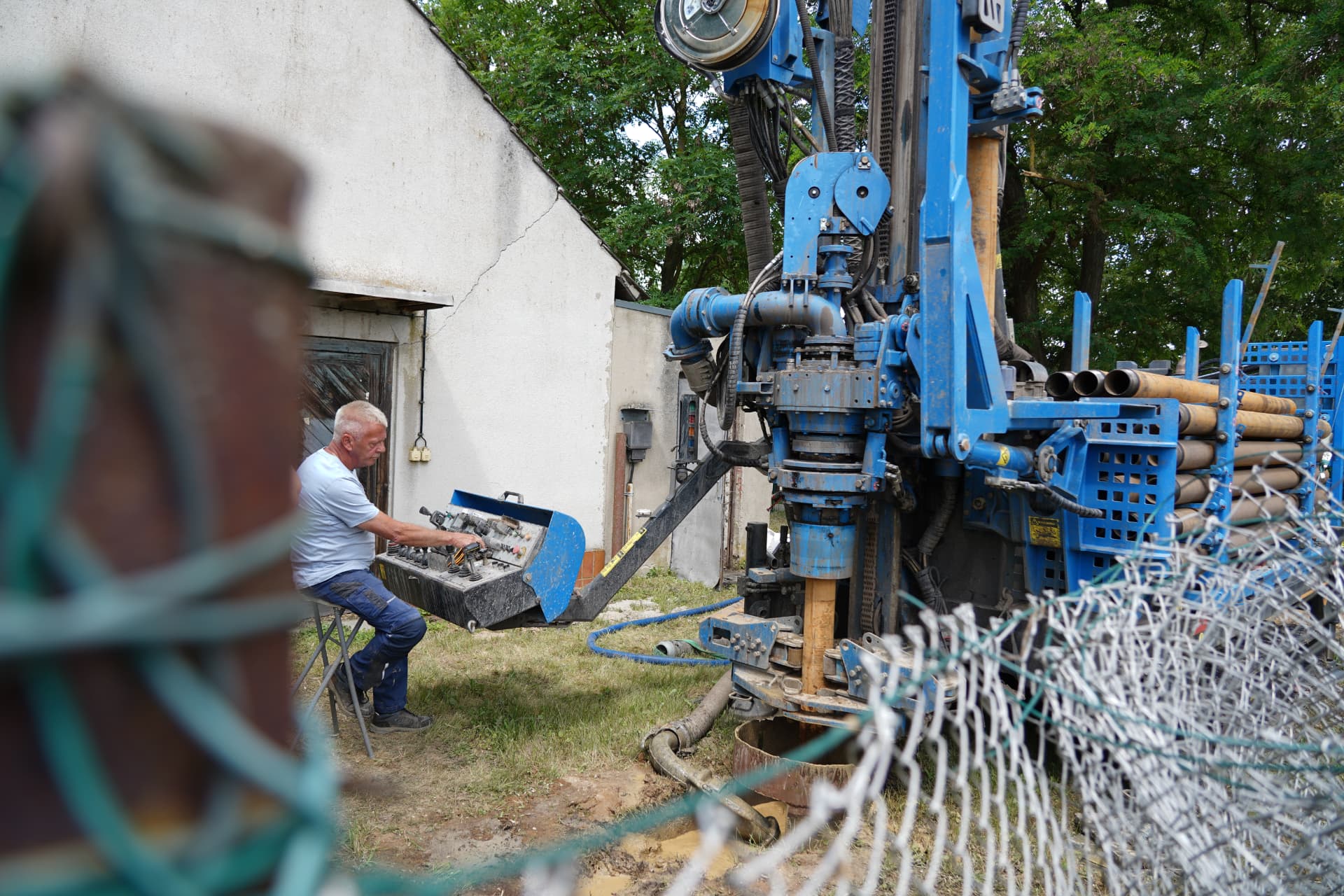 Bohrmeister der Gesche-Brunnenbaugesellschaft Lebus an der Steuerung der Bohranlage auf einem Grundstück